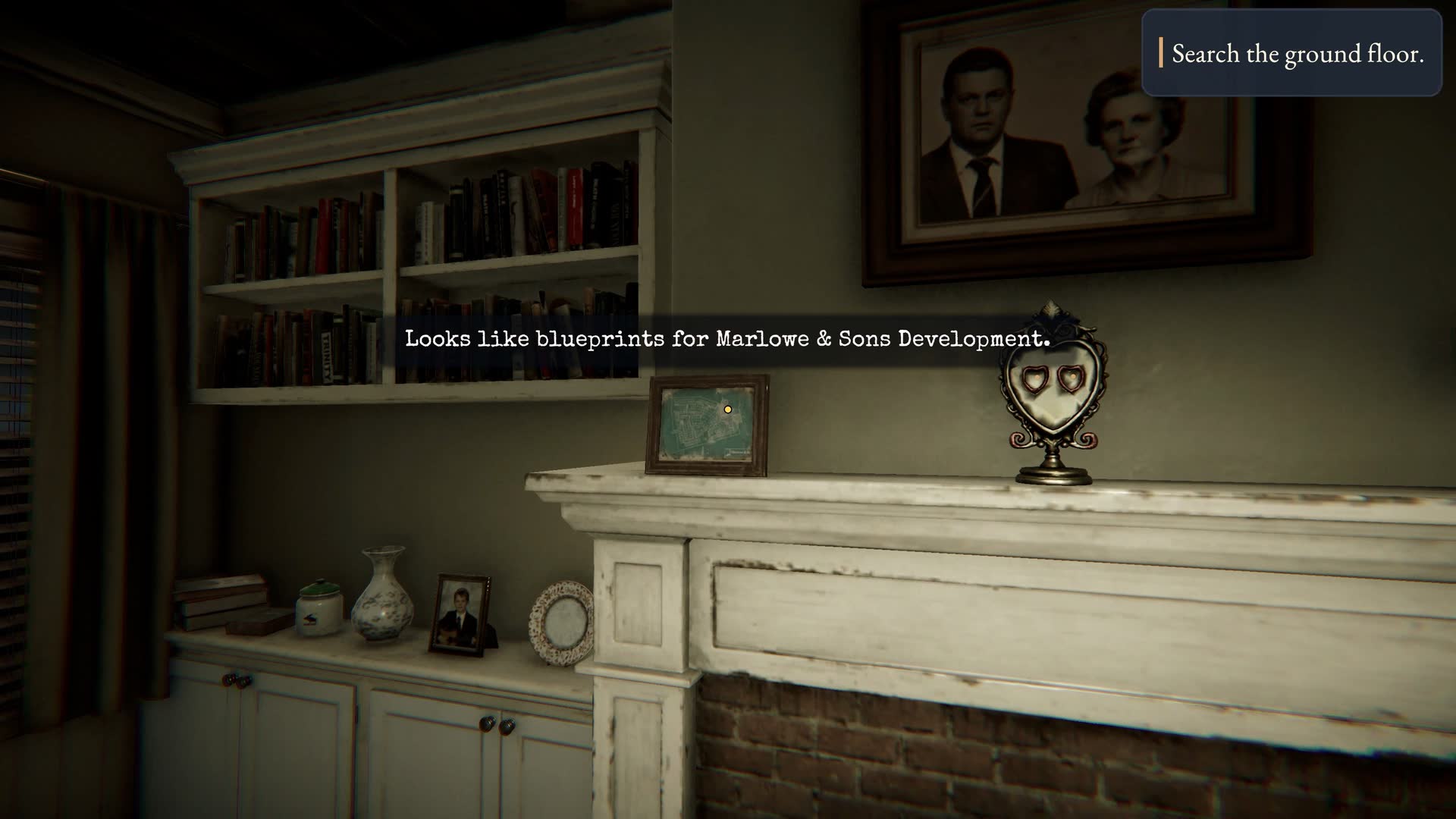 Hollowmere — The living room at night — fireplace, bookshelves and a family portrait above the mantel